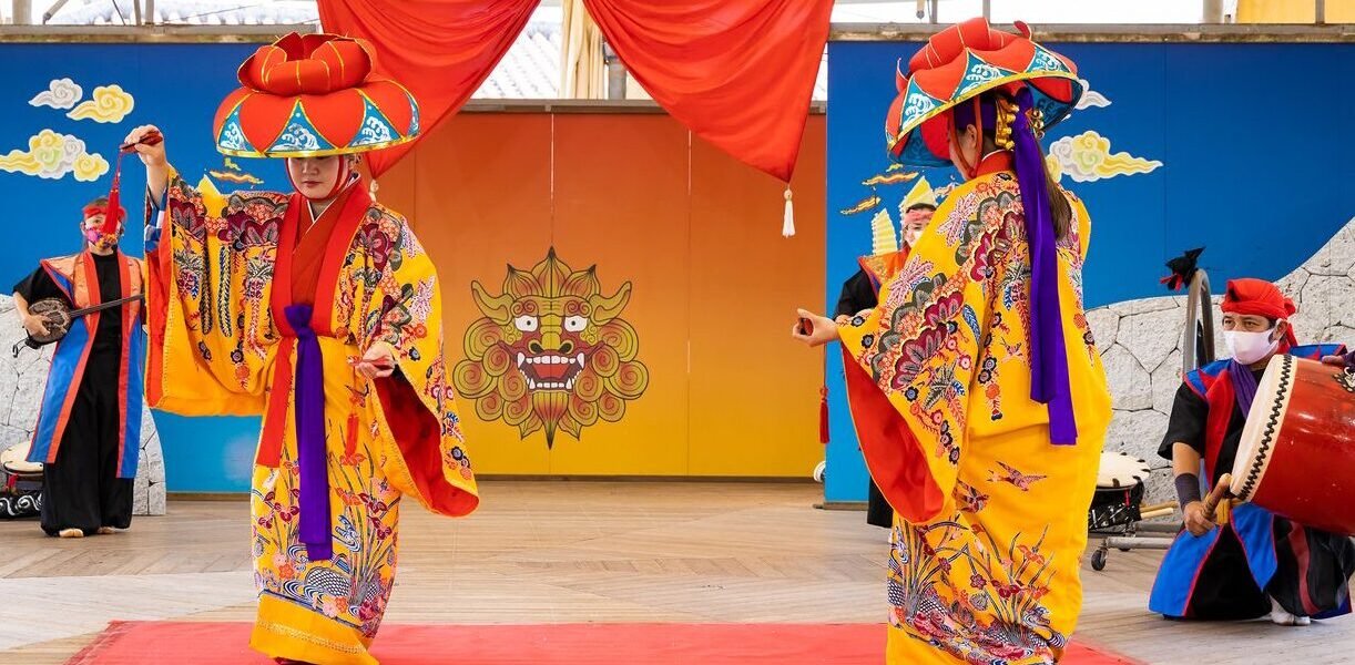 Trois musiciens vêtus de tenues traditionnelles jouent du sanshin, un instrument emblématique de la culture d’Okinawa 1858636